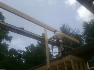 Carpenter setting a ridge beam over a new addition frame — Ice Dam Removal by Roofing Brothers in Pine Hill