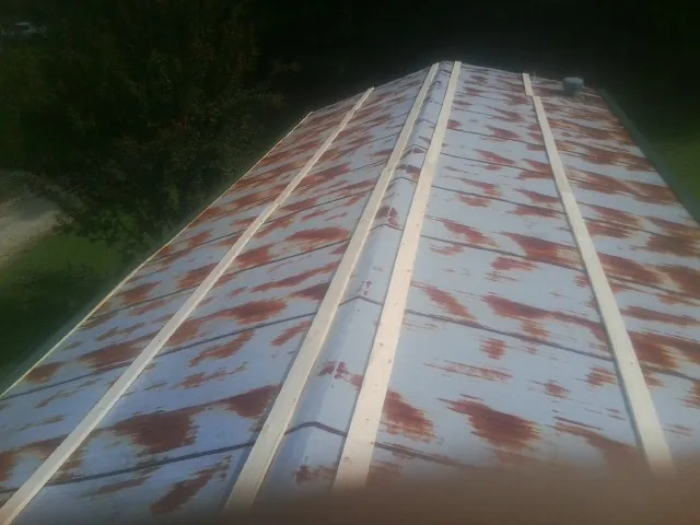 Rusted metal roof panels with new wood purlins before replacement — Storm Damage Roof Repair in Pine Hill by Roofing Brothers